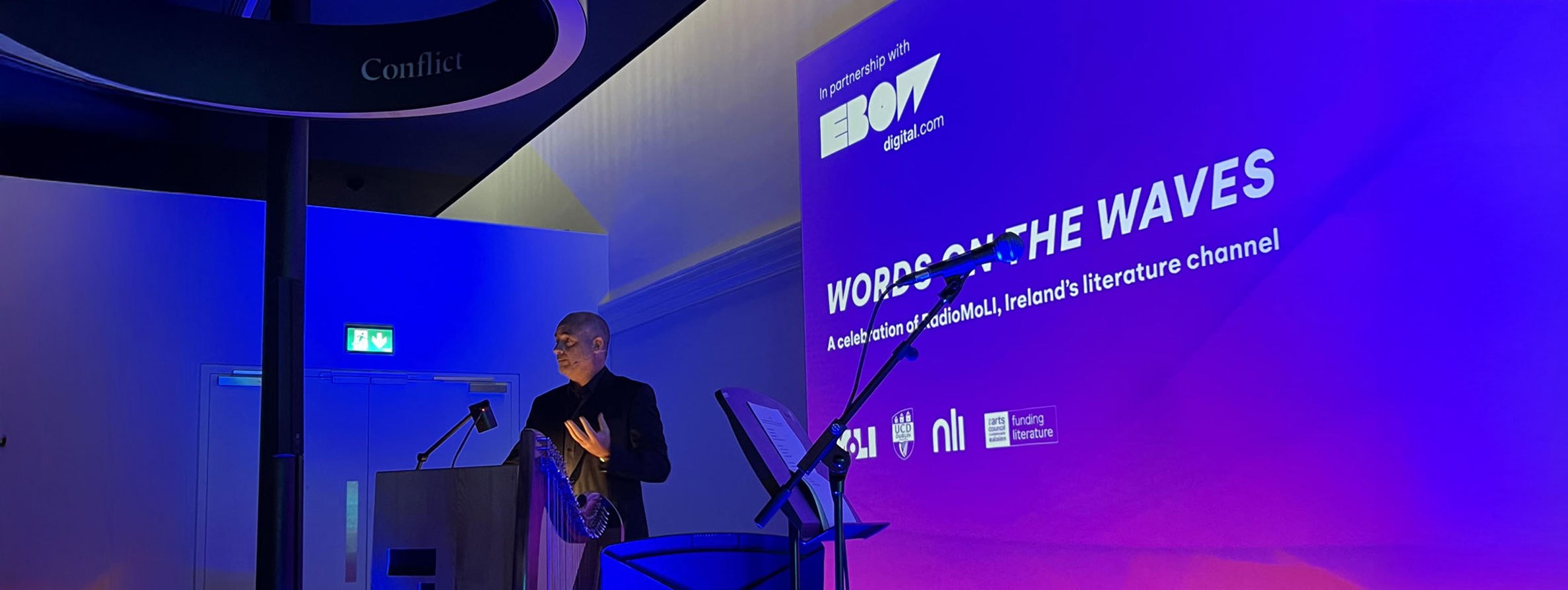 David Douglas, MD of Ebow Digital, standing at a MOLI-branded podium giving a speech.